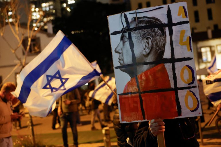 A demonstrator holds a placard with an image of Israeli Prime Minister Benjamin Netanyahu during a protest against Netanyahu's government, amid the ongoing conflict between Israel and the Palestinian Islamist group Hamas from Gaza, in Tel Aviv, Israel March 2, 2024. REUTERS/Carlos Garcia Rawlins